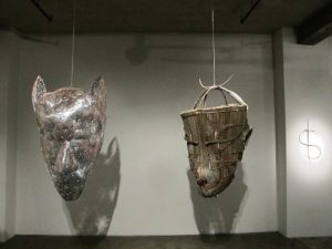 Two large sculptures of faces hanging from the ceiling